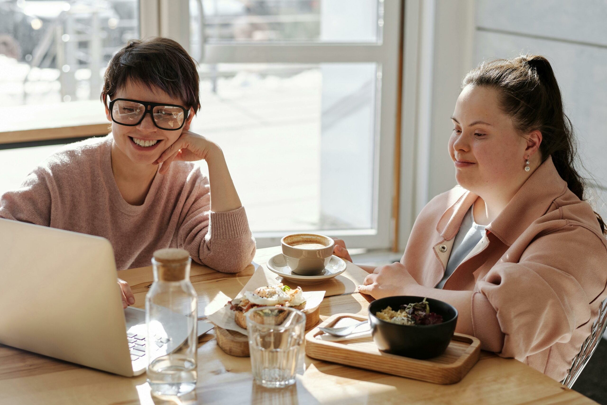 Two girls chatting and laughing around table